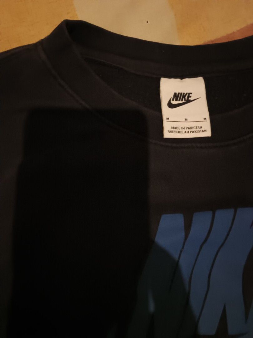 Nike sweet shirt (Category: Activewear) located in Odiongan. Submitted by thriftngo26 (Listing ID 1470267185, Image 3). Description: This item is the Nike Sportswear Sport Essentials+ Brushed Back Fleece Crew Sweatshirt (Style Code: DM6875-010 / DM6876-010), which features a "glitch in the system" graphic style with stacked, multi-colored Nike Futura logos scattered across the front and sleeves.