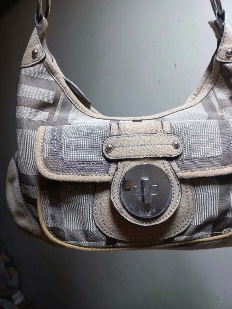 Nine West Shoulder Bag Checkered Pattern with Front Pocket (Category: Shoulder Bags) located in Manila. Submitted by dei03_diz (Listing ID 1470280709, Image 2). Description: - Brand: Nine West - Style: Shoulder bag with single strap design - Pattern/Color: Beige and brown checkered - Closure: Front flap pocket with circular turn-lock - Hardware: Silver-tone - Interior: Dark brown lining with zippered and slip pockets - Origin: Made in China - Con