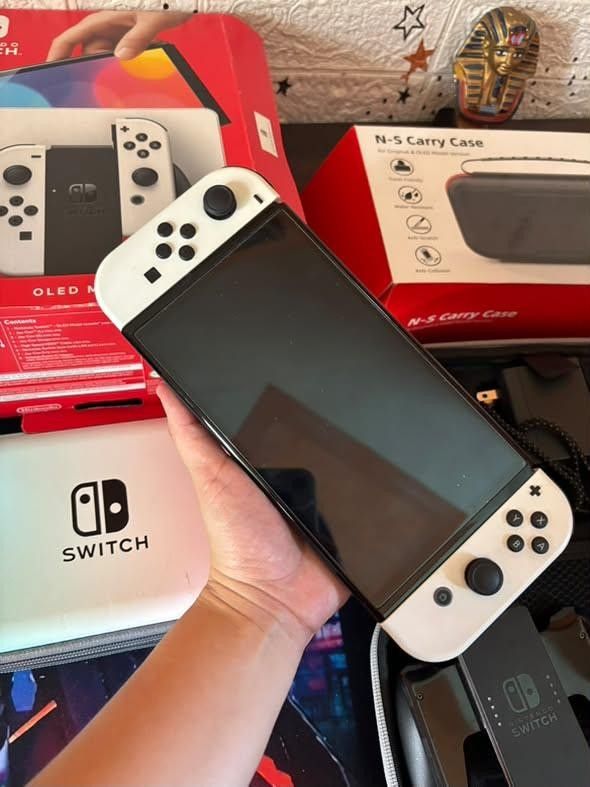 Nintendo Switch OLED Model White with Carrying Case (Category: Nintendo) located in Manila. Submitted by fast_chaeberry (Listing ID 1470179147, Image 3). Description: - Item: Nintendo Switch OLED Model (White) - Condition: Fully working, minor wear on the original box - Includes: Original box, charger, grip controller attachment, and standard Joy-Cons - Freebies: 2 carrying cases (1 gradient, 1 black) - Ideal for your next gaming setup!.