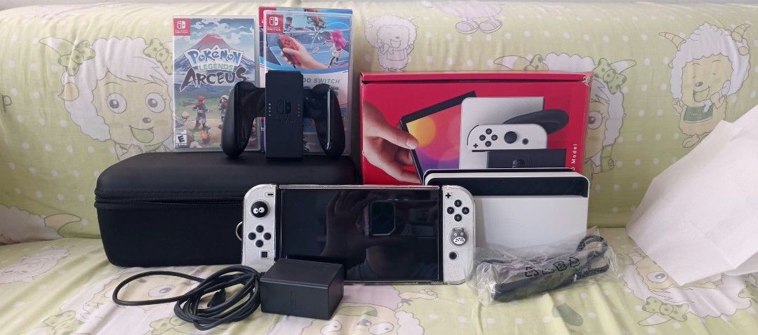 Nintendo Switch OLED White Console with Games and Accessories (Category: Nintendo) located in San Fernando. Submitted by pollygirl08 (Listing ID 1470263080, Image 2). Description: - Nintendo Switch OLED System (White) in excellent, fully working condition - Includes original box, dock, power adapter, and HDMI cable - - White Joy-Cons equipped with custom thumb grips, plus Joy-Con grip - Durable black carrying case included for safe travel - Two p