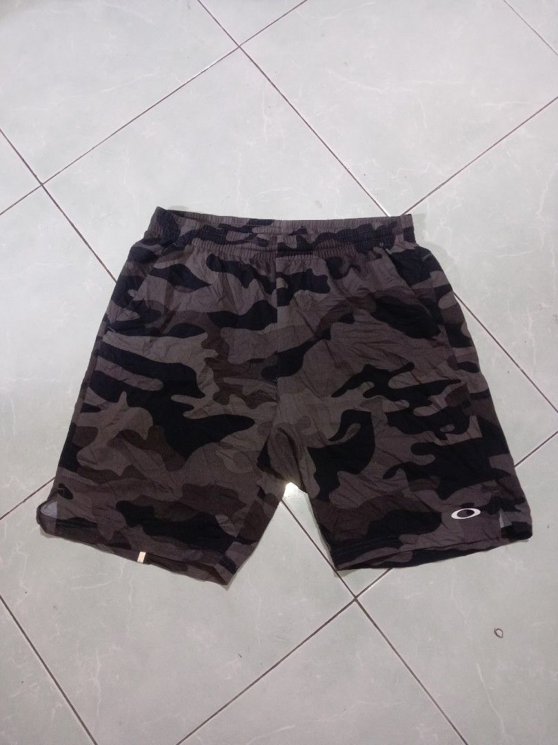 Oakley Performance Fit Camouflage Shorts (Category: Shorts) located in Nagcarlan. Submitted by asd0606 (Listing ID 1470240882, Image 1). Description: - Authentic Oakley performance shorts in a brown/black camouflage pattern - Comfortable performance fit with an elastic waistband and adjustable drawstring - Lightweight grid fabric construction inside for enhanced breathability - Features a small Oakley ellipse logo printed on the lower left leg - 