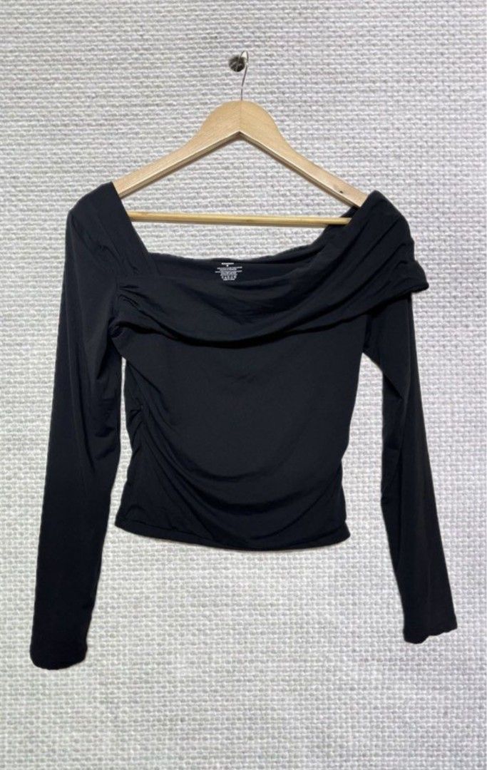 Off-shoulder long sleeve draped top (Category: Longsleeves) located in San Carlos. Submitted by my.excess.stuff (Listing ID 1470344304, Image 2). Description: - Color: Black - Style: Off-shoulder long sleeve with draped overlay neckline - Fit: Body-hugging soft stretch fabric with flattering ruched sides - Size: Medium (tag attached) - Versatile piece: Great for going out or pairing with denim jeans.