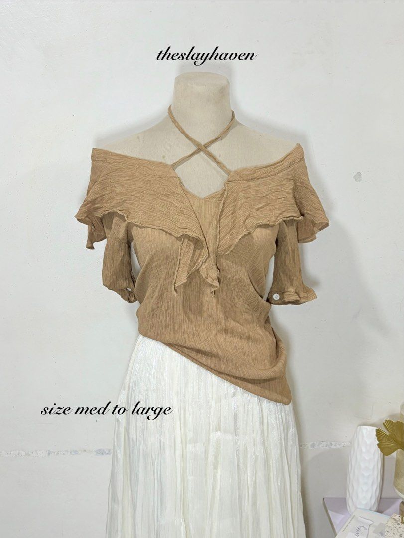 Off-shoulder ruffle top in light brown size medium to large (Category: Blouses) located in Manila. Submitted by biacakes (Listing ID 1470262774, Image 1). Description: - Color: Light brown - Style: Off-shoulder blouse with short sleeves - Design: Ruffled neckline and criss-cross halter straps - Fit: Relaxed fit, hits past the waistline - Material: Soft textured fabric - Size: Fits Medium to Large - Condition: Great addition to your casual wardrob