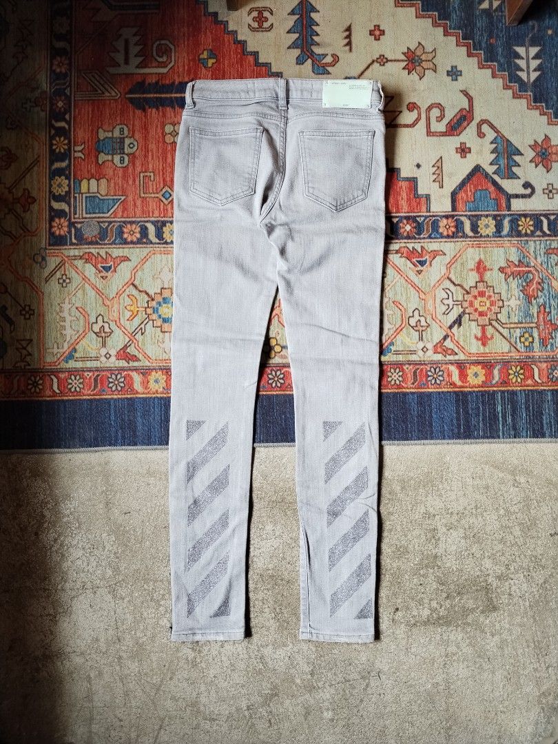 Off-White Grey Denim Embroidered Arrows (Category: Jeans) located in Pasig City. Submitted by loveforlux_2025 (Listing ID 1470237141, Image 3). Description: - Brand: Off-White -25 to 26 waist - Collection: 2013 (Main label verified) - Style: Grey skinny denim jeans / Slim fit - Details: Iconic industrial strap lettering down legs, glitter diagonal stripes on back ankles - Hardware: Exposed front zipper with ring pull, hook-and-eye waist closure -