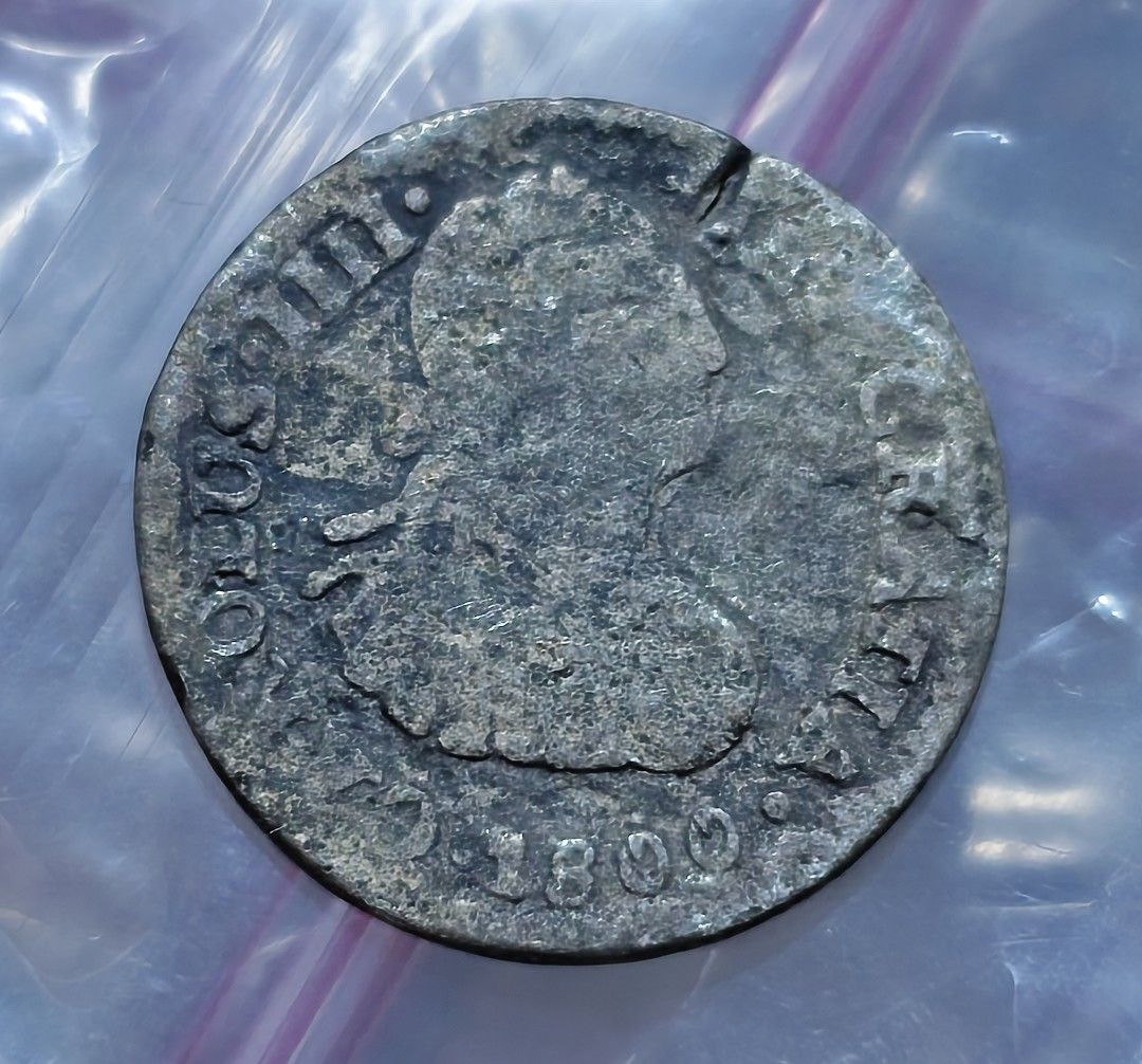 Old Vintage Spanish Colonial Coin Dated 1800 (Category: Currency) located in Taguig. Submitted by ezekiel103 (Listing ID 1470223019, Image 1). Description: - Authentic 1800 ½ reales Spanish Colonial era coin - Obverse: Features classic royal bust profile with rim lettering - Reverse: Displays national coat of arms flanked by pillars - Condition: Heavy vintage patina, worn surfaces, and natural surface corrosion - Shape: Circular with visible edge