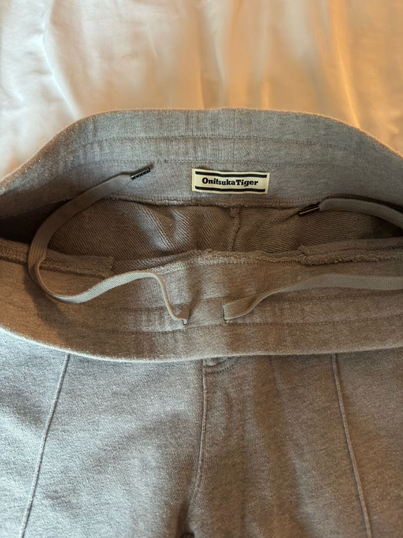 Onitsuka Tiger Grey Sweatpants Track Pants Medium (Category: Joggers) located in Cebu City. Submitted by _t.rix (Listing ID 1470181145, Image 3). Description: - Brand: Onitsuka Tiger - Color: Grey - Material: Soft sweatshirt fabric - Fit: Relaxed fit through the legs with a drawstring waistband - Details: Front center crease stitching and single back pocket - Condition: Clean overall, perfect for lounging or casual wear.