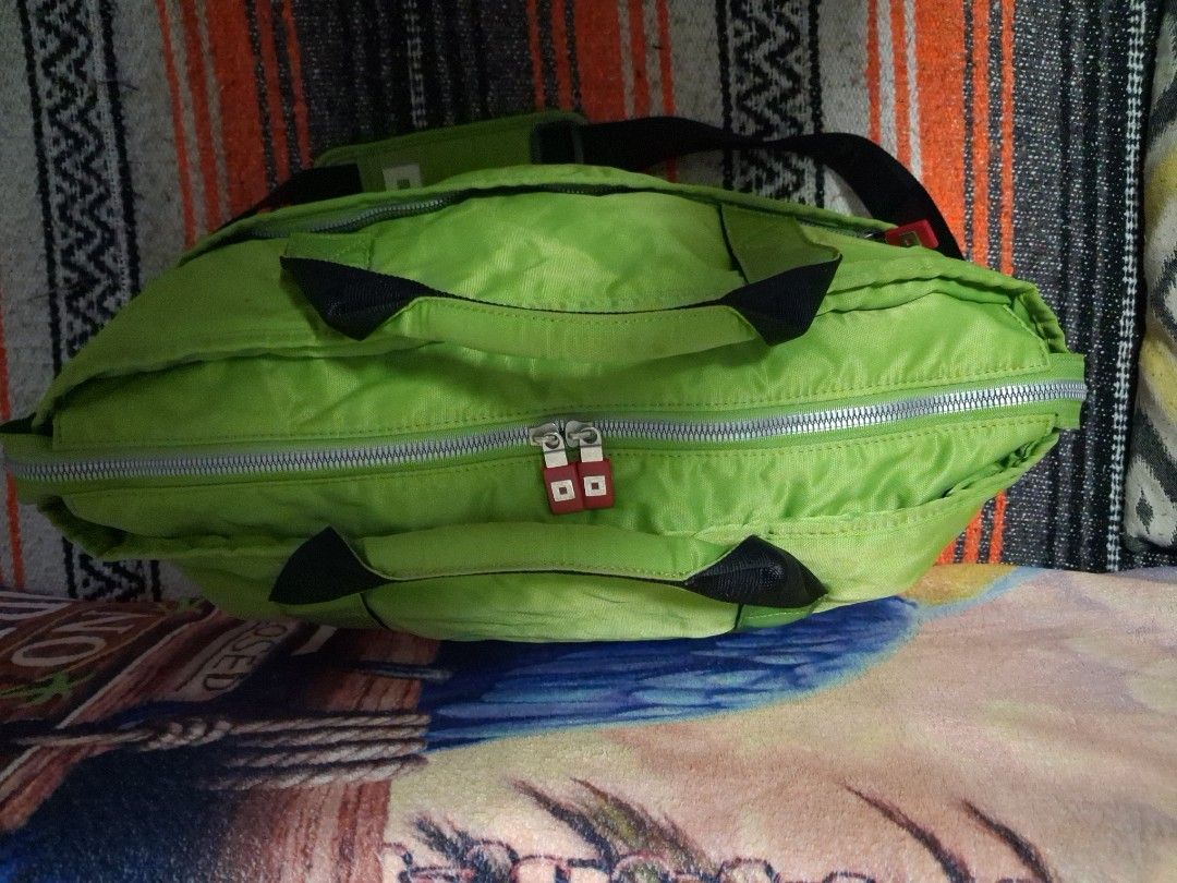 Travel bag (Category: Shoulder Bags) located in Angeles City. Submitted by anneps (Listing ID 1470213325, Image 2). Description: - Brand: ONOFF - Color: Bright lime green with black strap and red accents - Features 'Golf matters' branding patch on the front - Double top handles and wide detachable black shoulder strap with padded cushion - Secure silver zip closure with red pull tabs - Front slip pockets for quick access - Spacious interior with 