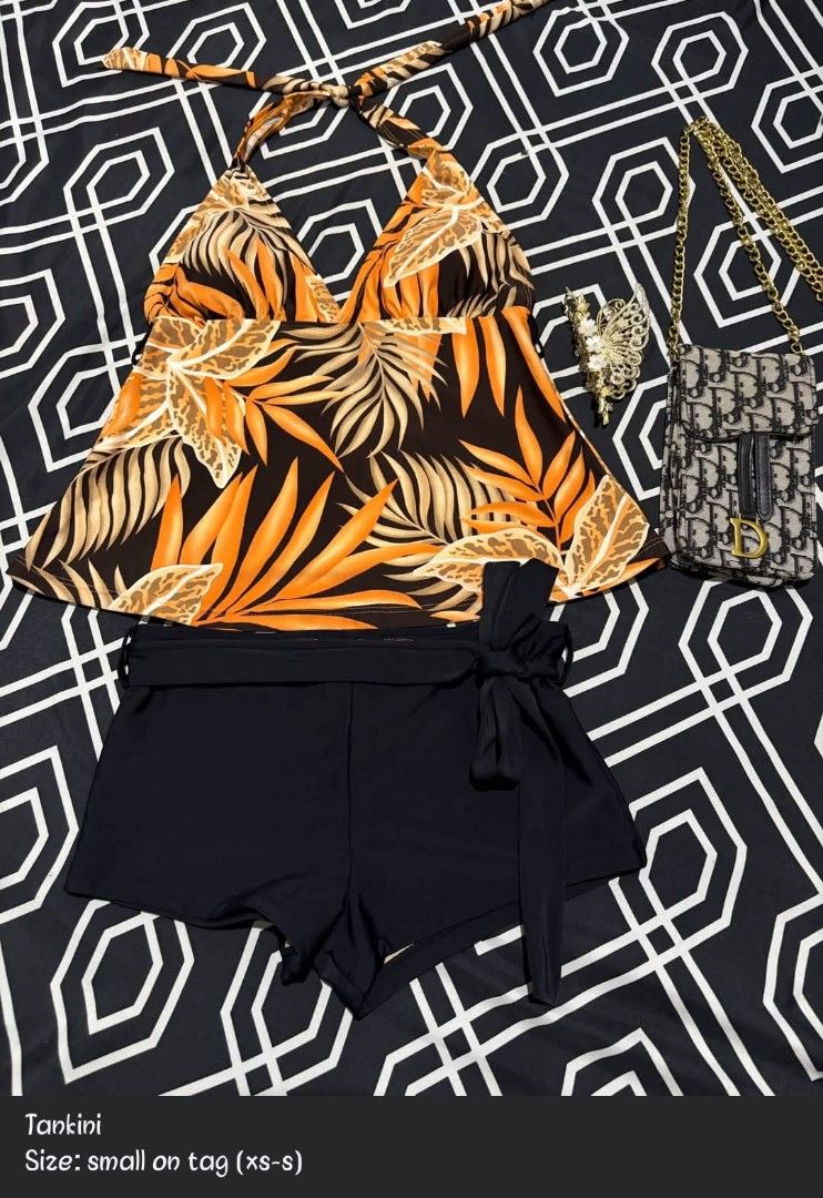 Orange Leaf Print Halter Tankini with Black Shorts (Category: Bikinis & Swimsuits) located in Manila. Submitted by chelshoppe (Listing ID 1470177312, Image 1). Description: - Style: Orange and black leaf print halter tankini top with matching black swim shorts - Detail: Shorts feature a stylish side tie belt - Size: Fits XS to S - Condition/Use: Brand new look, great for vacations and beach days - Shipping: Fast shipping available via J&T .