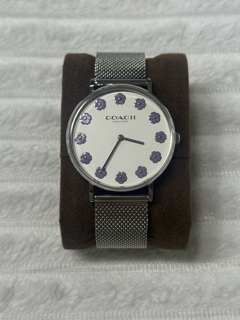 ORIGINAL Coach Perry 14504100 Watch (Category: Women's Watches) located in Manila. Submitted by fatz91 (Listing ID 1470218679, Image 1). Description: Coach Perry 14504100 Watch The visual highlight is the white dial with twelve lavender/purple floral markers. That combination gives it more personality than a conventional silver dress watch while remaining fairly understated from a distance; the mesh bracelet also makes it easy to pair with jewelr