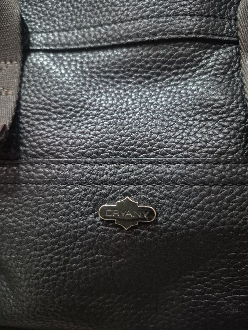 Oryany Black Leather Handbag with Shoulder Strap (Category: Luxury Bags & Wallets) located in Iloilo. Submitted by gorgeoustatz (Listing ID 1470281231, Image 2). Description: Ganda ng Size!!! Black pebbled leather handbag from Oryany. Includes matching detachable shoulder strap and sturdy carry handles with metallic stud accents. Main zip compartment opens to a green patterned fabric lining with an internal zippered pocket. Front side displays em