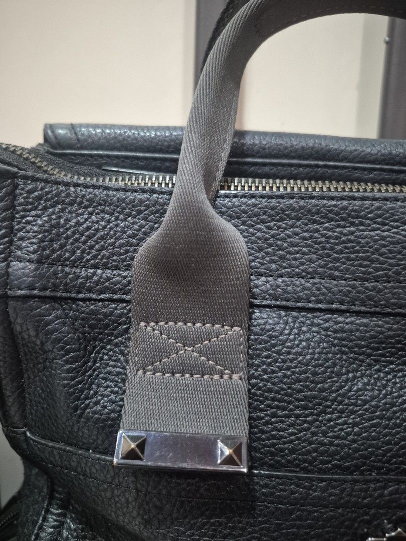 Oryany Black Leather Handbag with Shoulder Strap (Category: Luxury Bags & Wallets) located in Iloilo. Submitted by gorgeoustatz (Listing ID 1470281231, Image 3). Description: Ganda ng Size!!! Black pebbled leather handbag from Oryany. Includes matching detachable shoulder strap and sturdy carry handles with metallic stud accents. Main zip compartment opens to a green patterned fabric lining with an internal zippered pocket. Front side displays em