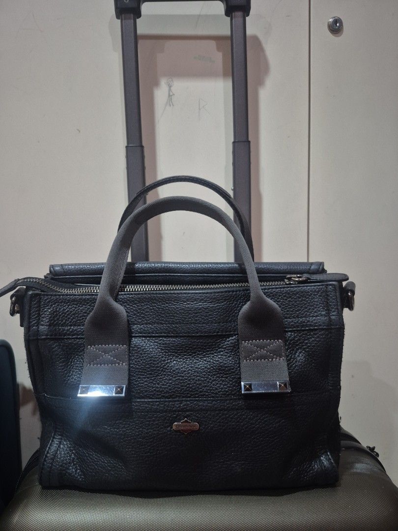 Oryany Black Leather Handbag with Shoulder Strap (Category: Luxury Bags & Wallets) located in Iloilo. Submitted by gorgeoustatz (Listing ID 1470281231, Image 1). Description: Ganda ng Size!!! Black pebbled leather handbag from Oryany. Includes matching detachable shoulder strap and sturdy carry handles with metallic stud accents. Main zip compartment opens to a green patterned fabric lining with an internal zippered pocket. Front side displays em
