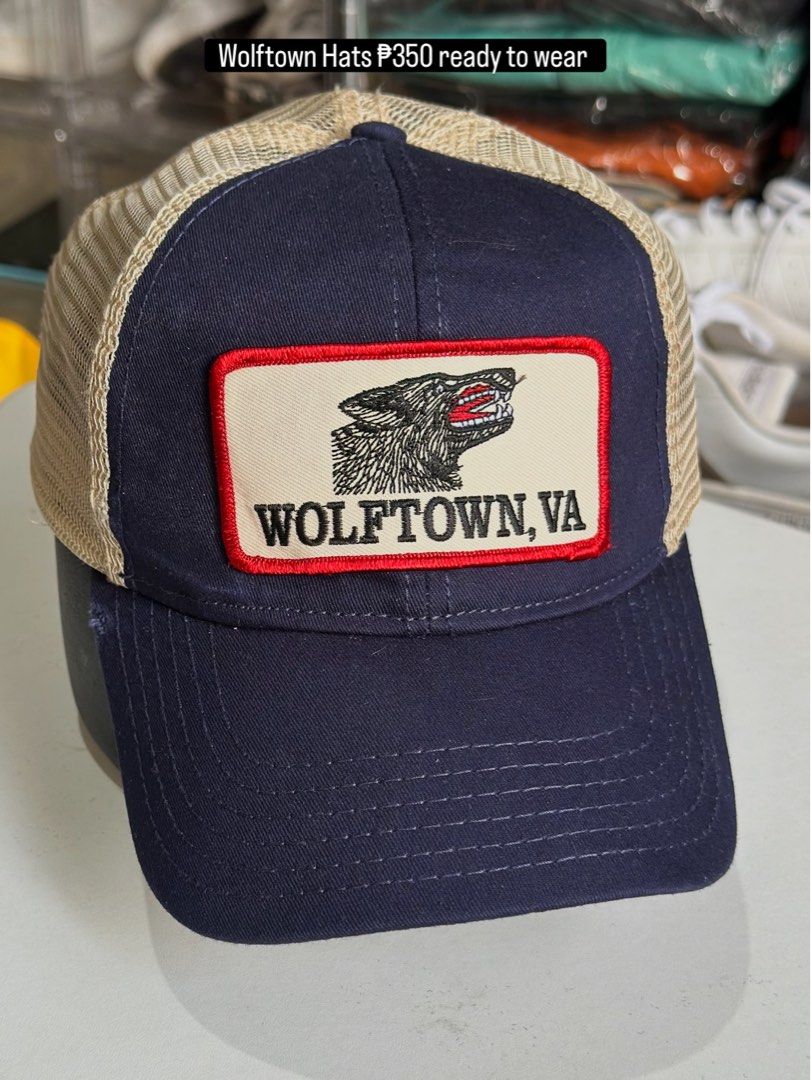 OTTO Wolftown VA Trucker Hat Navy Tan Snapback (Category: Caps & Hats) located in Daet. Submitted by thrifthings2018 (Listing ID 1470204933, Image 1). Description: - Brand: OTTO - Colorway: Navy front with tan mesh back - Design: Embroidered 'Wolftown, VA' patch with howling wolf graphic - Closure: Adjustable tan snapback - Condition: Clean inner sweatband, structured panels, ready to wear.