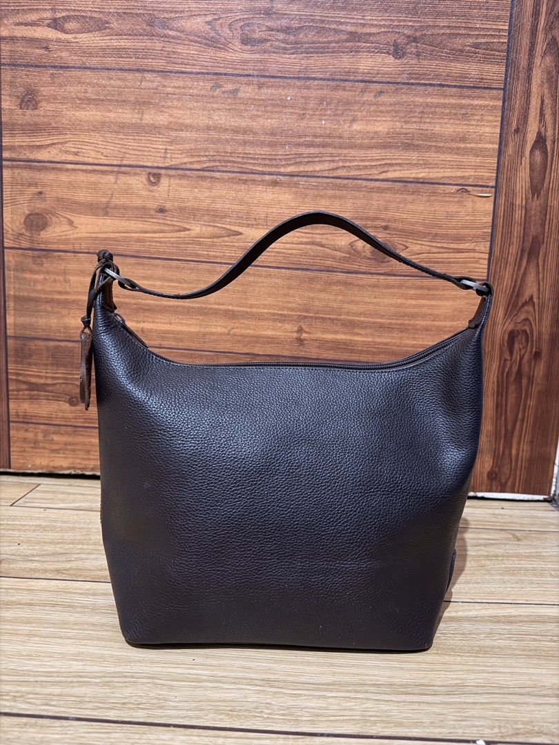 Our Tribe Brown Leather Shoulder Bag (Category: Shoulder Bags) located in Manila. Submitted by edricatrixie_ (Listing ID 1470173365, Image 1). Description: - Brand: Our Tribe - Material: Premium brown pebble grain leather - Closure: Secure top zipper - Strap: Single adjustable strap with stylish metal rings - Design: Structured trapezoid shape with detailed side seams - Accent: Signature Our Tribe leather logo tag near the handle - Condition: Exc