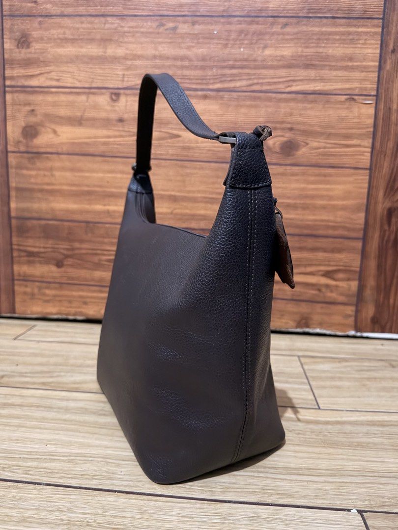 Our Tribe Brown Leather Shoulder Bag (Category: Shoulder Bags) located in Manila. Submitted by edricatrixie_ (Listing ID 1470173365, Image 3). Description: - Brand: Our Tribe - Material: Premium brown pebble grain leather - Closure: Secure top zipper - Strap: Single adjustable strap with stylish metal rings - Design: Structured trapezoid shape with detailed side seams - Accent: Signature Our Tribe leather logo tag near the handle - Condition: Exc