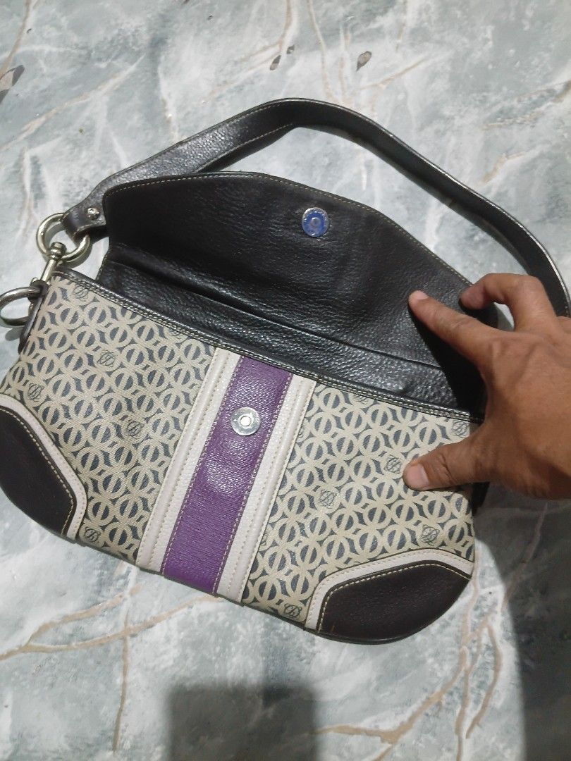 Patterned shoulder bag with purple stripe and dark brown leather (Category: Shoulder Bags) located in Cavite. Submitted by jaimebuala31560 (Listing ID 1470193404, Image 2). Description: - Eye-catching geometric patterned body - Premium dark brown leather trim - Distinct purple center stripe and matching shoulder strap accent - Secure front flap closure with magnetic snap button - Stylish silver-tone hardware links.
