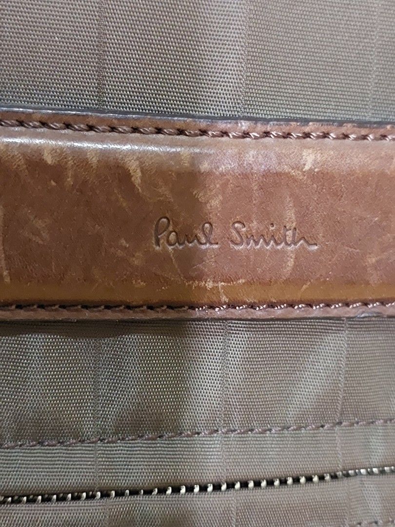 Paul Smith Brown Nylon Leather Briefcase Bag (Category: Briefcases) located in Malabon City. Submitted by jullie_bag_shop (Listing ID 1470271031, Image 2). Description: - Authentic Paul Smith briefcase in stylish brown nylon and leather - Double top handles with embossed logo patch - Secure zip exterior closure with magnetic snap top - Spacious interior lined in brown fabric with signature red trim - Includes internal zipped pocket, slip pockets,
