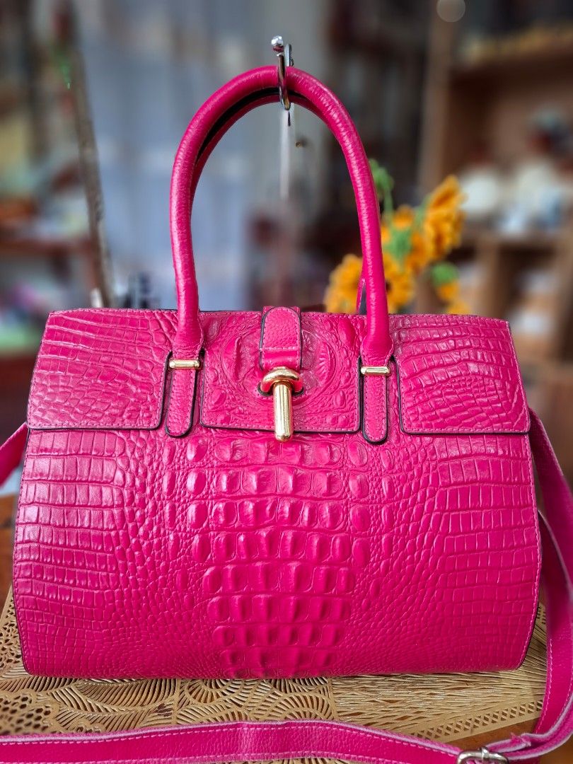 Pink Crocodile Embossed Leather Handbag with Crossbody Strap (Category: Tote Bags) located in Libon. Submitted by jaladzarmi80045 (Listing ID 1470224729, Image 2). Description: - Vibrant hot pink handbag with a stylish faux crocodile embossed texture - Elegant gold-tone hardware and protective metal feet on the bottom base - Dual top grab handles and a matching adjustable shoulder strap - Secure turn-lock closure on the front flap - Exterior vert