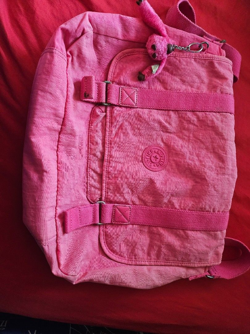 Pink Kipling Crossbody Bag with Monkey Keychain (Category: Cross-body Bags) located in Mandaluyong City. Submitted by ohwmaria (Listing ID 1470240841, Image 2). Description: - Needs washing, folds due to storage but they should smooth out naturally with use. Authentic Kipling messenger bag in a vibrant bright pink shade - Made from signature durable and lightweight crinkle nylon - Flap closure with double vertical straps and metal buckles - Conve