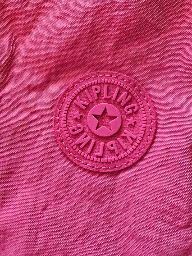 Pink Kipling Crossbody Bag with Monkey Keychain (Category: Cross-body Bags) located in Mandaluyong City. Submitted by ohwmaria (Listing ID 1470240841, Image 3). Description: - Needs washing, folds due to storage but they should smooth out naturally with use. Authentic Kipling messenger bag in a vibrant bright pink shade - Made from signature durable and lightweight crinkle nylon - Flap closure with double vertical straps and metal buckles - Conve