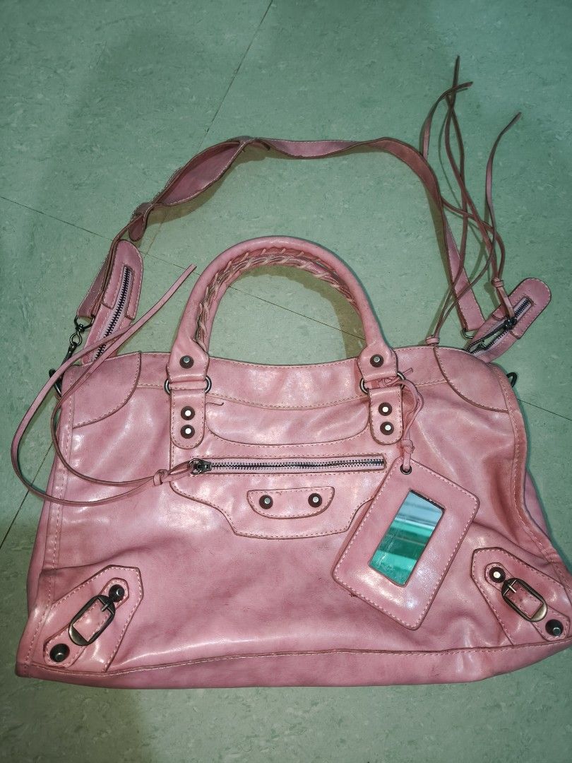 Pink motorcycle style leather handbag with mirror (Category: Luxury Bags & Wallets) located in Davao. Submitted by navil01 (Listing ID 1470313768, Image 1). Description: - Style: Classic motorcycle bag design in a vibrant bright pink leather - Straps: Double top handles and an adjustable shoulder strap with tassels - Details: Front zip pocket, edgy metal studs, buckle corners, and a matching pink framed mirror - Interior: Fabric-lined with a conv