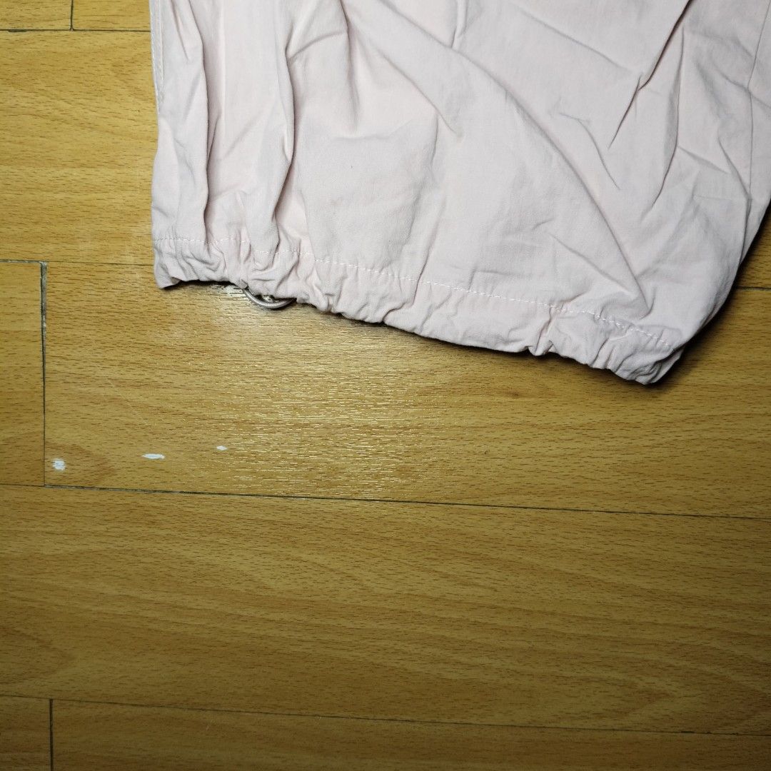 Pink Parachute Pants Wide Leg Drawstring Hem (Category: Jeans) located in Manila. Submitted by usedtobeyours26 (Listing ID 1470329391, Image 3). Description: - Color: Light pink - Fit: Comfortable elastic waistband, wide-leg design - Style: Techwear and streetwear aesthetic - Details: Layered front panels, two flaps back design - Feature: Adjustable drawstring toggles at the hems Disclaimer: Product Color May Slightly Vary Due to Photographic Lig