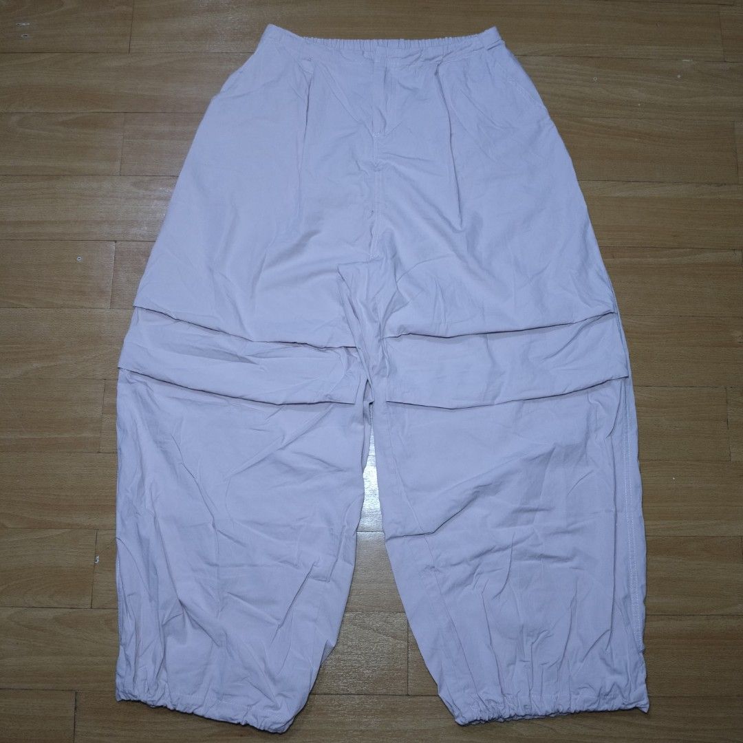 Pink Parachute Pants Wide Leg Drawstring Hem (Category: Jeans) located in Manila. Submitted by usedtobeyours26 (Listing ID 1470329391, Image 1). Description: - Color: Light pink - Fit: Comfortable elastic waistband, wide-leg design - Style: Techwear and streetwear aesthetic - Details: Layered front panels, two flaps back design - Feature: Adjustable drawstring toggles at the hems Disclaimer: Product Color May Slightly Vary Due to Photographic Lig