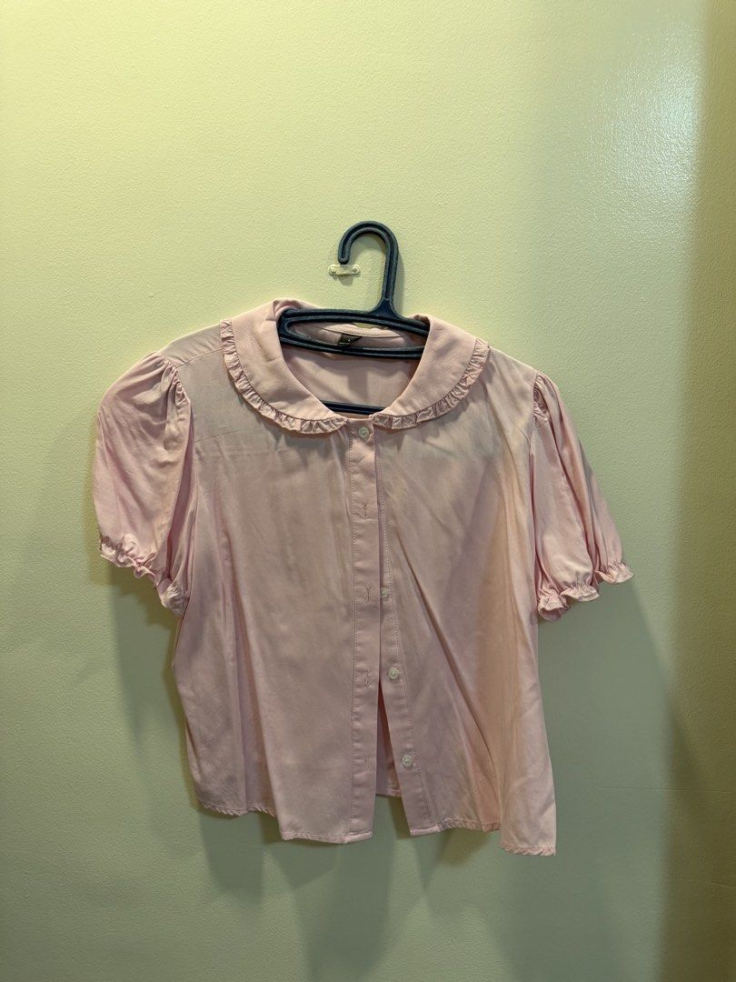 Pink Short Sleeve Blouse with Ruffled Collar | L (Category: Blouses) located in Caloocan City. Submitted by hobieshome (Listing ID 1470289016, Image 1). Description: - Color: Light pink - Style: Button-up blouse with short sleeves - Details: Elastic ruffled cuffs and matching ruffled round collar - Fit: Regular fit, lightweight fabric - Pairing: Great with skirts or high-waisted denim pants - Condition: Excellent, clean with no stains or flaws.