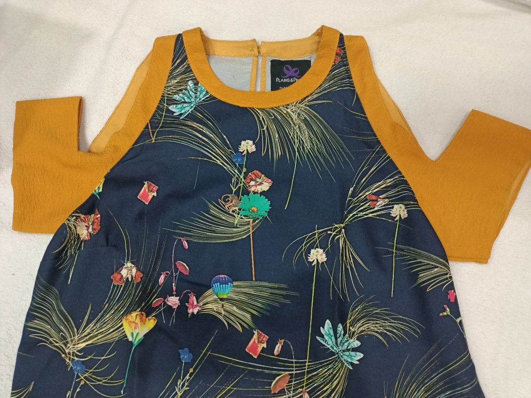 Plains & Prints Floral Cold Shoulder Blouse Size M (Category: Blouses) located in Manila. Submitted by jollynest24 (Listing ID 1470280423, Image 3). Description: - Brand: Plains & Prints - Design: Colorful botanical print on dark navy fabric with mustard yellow trim - Details: Cold shoulder sleeves, back neck button closure - Size: PHL M, EUR 10, USA 6 - Fabric: Lightweight and comfortable - Styling: Great for pairing with jeans or skirts - Condi