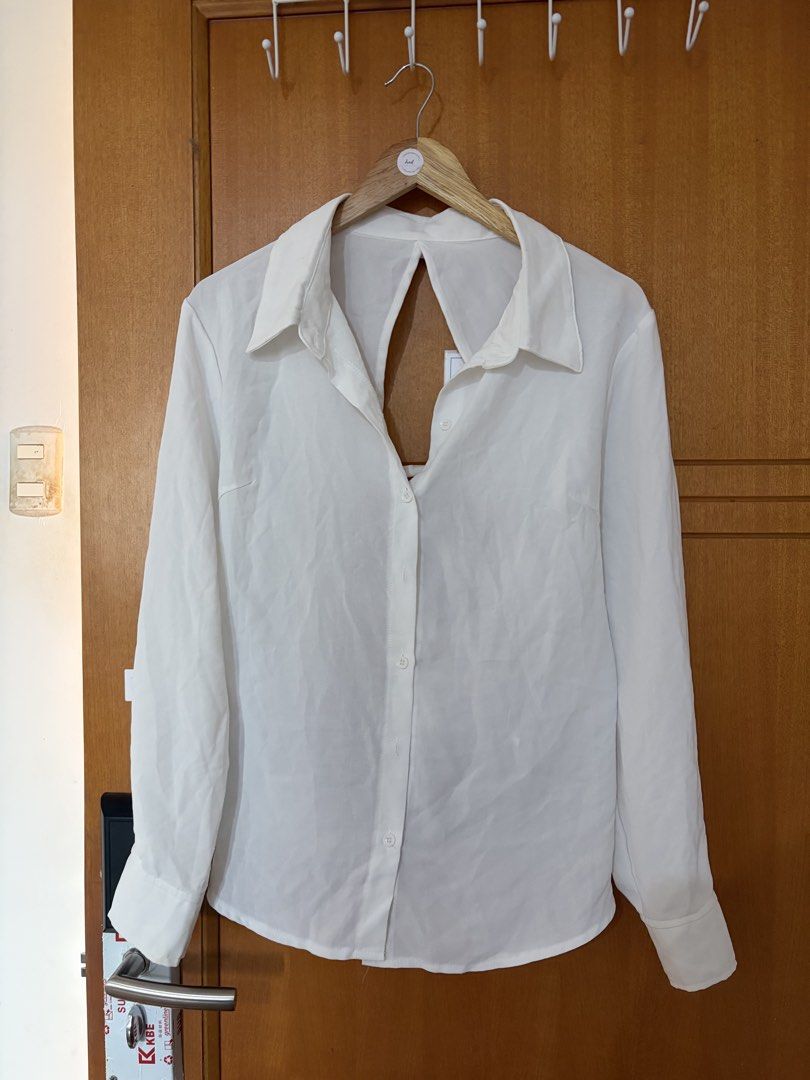 Plus size White long sleeve button down blouse with criss-cross back (Category: Longsleeves) located in Taguig. Submitted by preloved_by_janel (Listing ID 1470273715, Image 2). Description: - Style: Long-sleeve button-down with classic collar - Unique feature: Statement cutout back with criss-cross ribbon ties - Details: Button cuffs, lightweight fabric - Needs wash since stored in the cabinet -Best fit 0xl body frame.