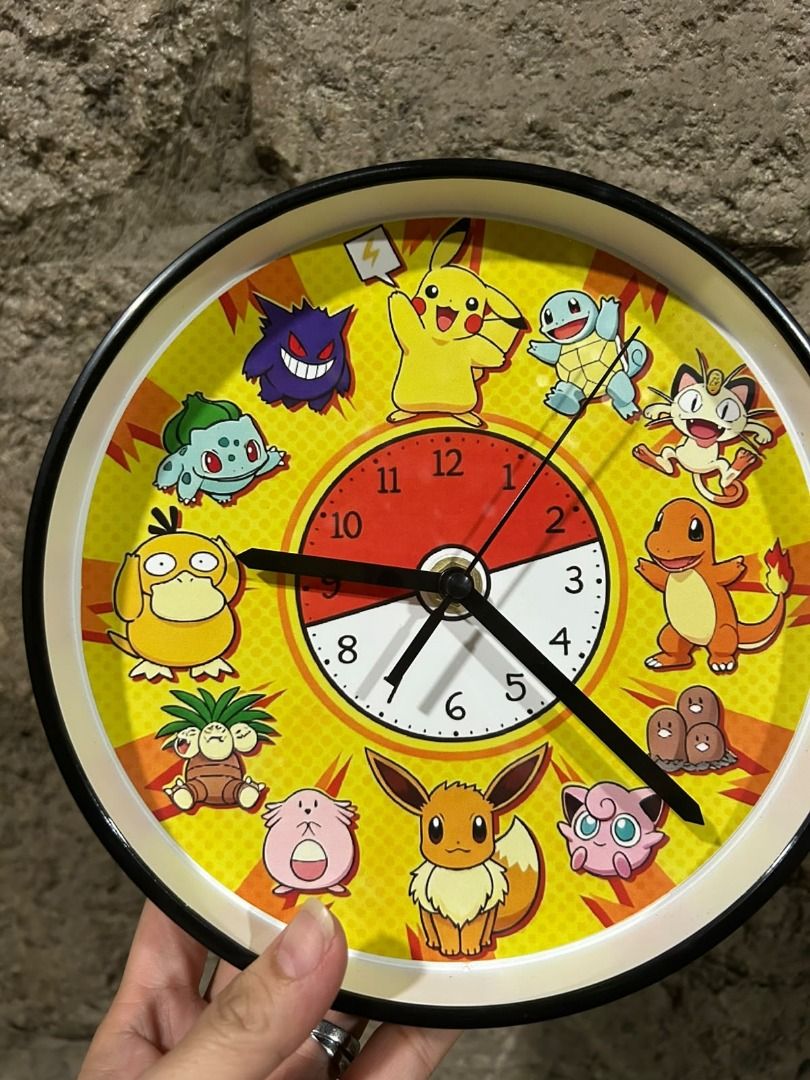 Pokemon Characters Wall Clock (Category: Clocks) located in Las Pinas. Submitted by whatzupriley (Listing ID 1470277971, Image 2). Description: - Design: Bright yellow background featuring classic Pokemon characters (Pikachu, Squirtle, Charmander, Bulbasaur, Eevee, Gengar, Psyduck) and a Pokeball center - Display: Clear, easy-to-read numbers with a sleek black frame - Ideal For: Kids' rooms, game rooms, offices, or any Pokemon fan's space - Condi