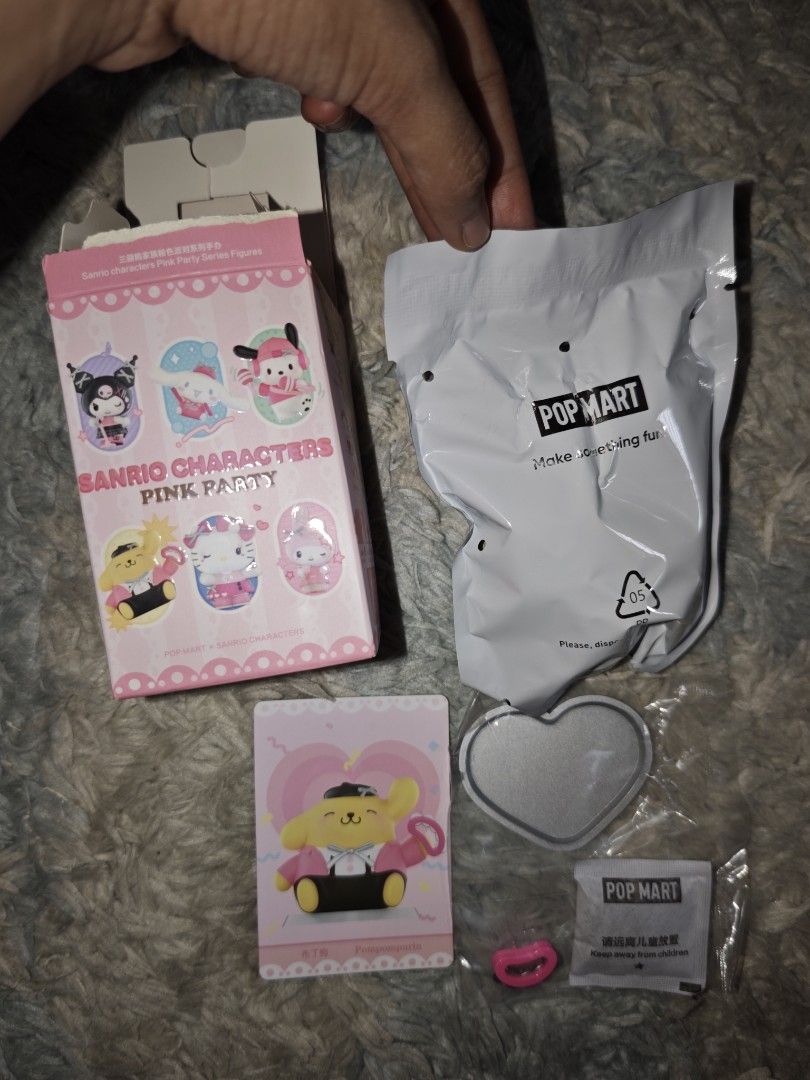 Pop Mart Sanrio Pink Party Pompompurin (Category: Designer & Blind Box Toys) located in Binan City. Submitted by kimencina (Listing ID 1470159072, Image 2). Description: - Pop Mart Sanrio Characters Pink Party Series - Character: Pompompurin (Pink jacket & black hat) - Condition: Brand new, opened box (to check card) with sealed inner foil - Inclusion: Character card, heart-shaped display base, accessory, box, and silica gel packet - Meet-ups and