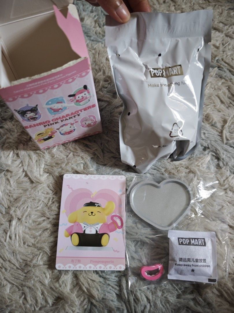 Pop Mart Sanrio Pink Party Pompompurin (Category: Designer & Blind Box Toys) located in Binan City. Submitted by kimencina (Listing ID 1470159072, Image 1). Description: - Pop Mart Sanrio Characters Pink Party Series - Character: Pompompurin (Pink jacket & black hat) - Condition: Brand new, opened box (to check card) with sealed inner foil - Inclusion: Character card, heart-shaped display base, accessory, box, and silica gel packet - Meet-ups and