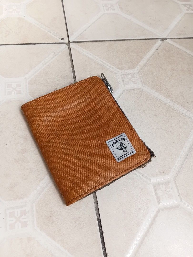 Porter International Bifold Wallet Brown Canvas (Category: Wallets & Card Holders) located in Manila. Submitted by grandflower-547aee (Listing ID 1470242650, Image 1). Description: - Brand: Porter International - Color/Material: Brown textured fabric - Closure: Secure snap button with exterior zip coin pocket on the back - Interior: Multiple card slots and slip compartments - Branding: Porter Made International woven label inside and front logo p