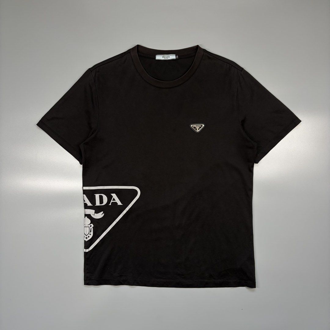 Prada Big Logo Reflectorized Logo Tee (OFF ONLY) (Category: Luxury Apparel) located in Cavite. Submitted by onebeancent (Listing ID 1470349072, Image 1). Description: (OFF ONLY / REFLECTORIZED SIDE PRINT) (Quickdry Material / Drifit) Size: Medium (Men) | XL (Women's) Dimension: 20" Width | 26" Length Color: Black Color Rate: 9/10 Issue: Slight Sunfade collar part Condition: Very good to Excellent Price: 780php Additional Shipping Fee (J&T Small P