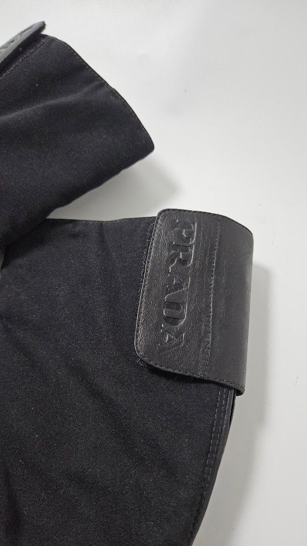 Prada Black Nylon and Leather Mid-Calf Boots (Category: Boots) located in Alfonso. Submitted by jbcamet (Listing ID 1470267296, Image 2). Description: - Brand: Prada - Style: Black mid-calf boots with a sporty design - Material: Combination of durable nylon fabric and premium leather - Closure: Back zipper with Prada Milano engraved hardware - Detailing: Leather top strap with embossed Prada logo and iconic red sole badge - Interior: Leather lini