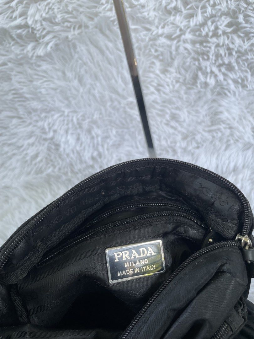 Prada Black Nylon Crossbody Bag (Category: Luxury Bags & Wallets) located in San Carlos. Submitted by jessamaep_deer (Listing ID 1470166232, Image 3). Description: - Authentic Prada crossbody bag in classic black nylon - Iconic silver triangular logo plaque on the front - Multiple exterior zipped compartments with branded rubber pull tabs - Secure main zipper with branded fabric interior lining - Features the classic silver "Prada Milano Made in 