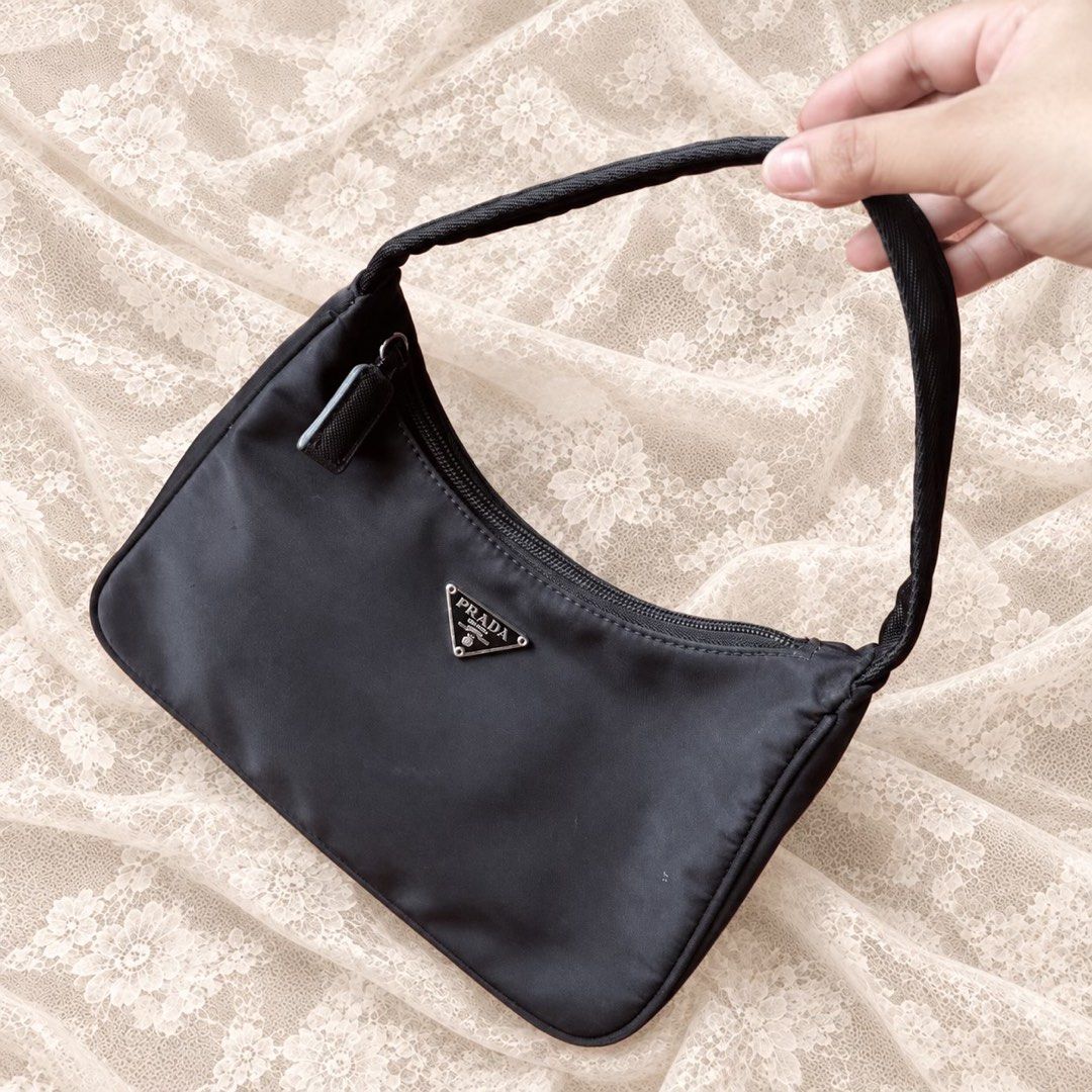 Prada Black Nylon Re-Edition Mini Shoulder Bag (Category: Luxury Bags & Wallets) located in Manila. Submitted by calliope777 (Listing ID 1470214068, Image 1). Description: - Prada mini shoulder bag in classic black nylon - Iconic triangular metal logo plaque on the front - Secure zip top closure with a comfortable single fabric strap - Clean interior lining featuring the metal brand plaque - Structured base maintains its shape effortlessly - Time