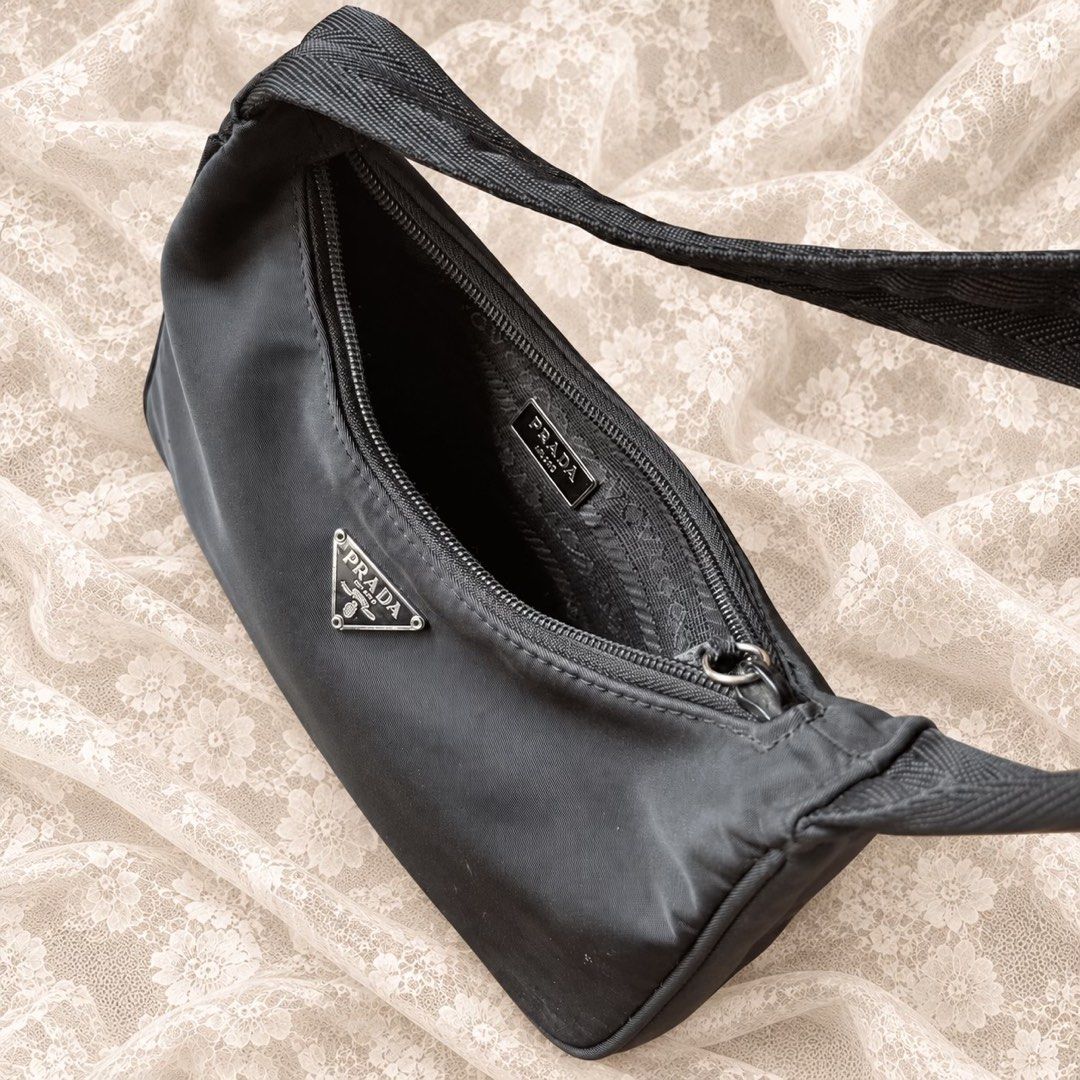 Prada Black Nylon Re-Edition Mini Shoulder Bag (Category: Luxury Bags & Wallets) located in Manila. Submitted by calliope777 (Listing ID 1470214068, Image 3). Description: - Prada mini shoulder bag in classic black nylon - Iconic triangular metal logo plaque on the front - Secure zip top closure with a comfortable single fabric strap - Clean interior lining featuring the metal brand plaque - Structured base maintains its shape effortlessly - Time