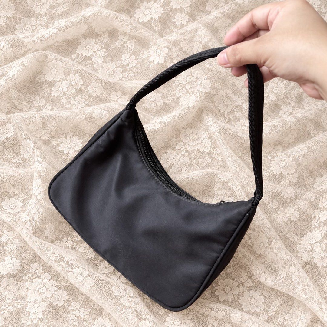 Prada Black Nylon Re-Edition Mini Shoulder Bag (Category: Luxury Bags & Wallets) located in Manila. Submitted by calliope777 (Listing ID 1470214068, Image 2). Description: - Prada mini shoulder bag in classic black nylon - Iconic triangular metal logo plaque on the front - Secure zip top closure with a comfortable single fabric strap - Clean interior lining featuring the metal brand plaque - Structured base maintains its shape effortlessly - Time