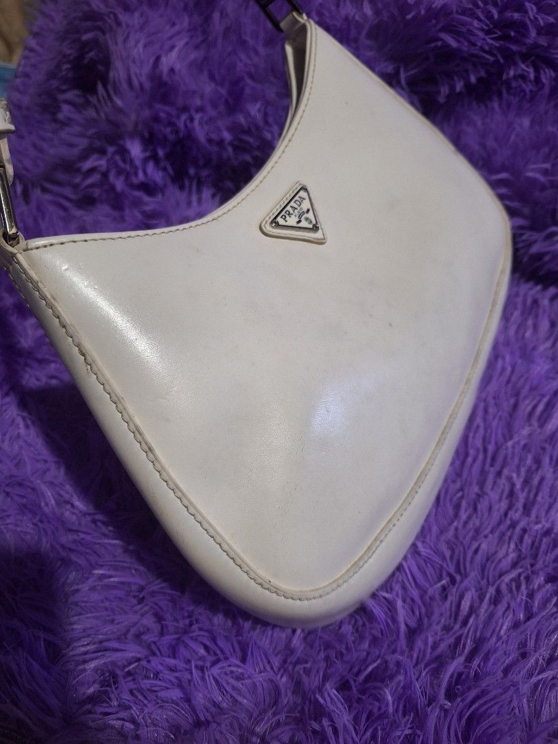 Prada CLEO White Leather Shoulder Bag (Category: Luxury Bags & Wallets) located in Quezon City. Submitted by cloudymay (Listing ID 1470202739, Image 3). Description: - Prada shoulder bag in classic white leather - Features the iconic enamel triangular logo plaque on the front - Sleek, slim profile with a structured silhouette - Silver-tone hardware accents at the strap connectors - Secure zip closure to keep daily essentials safe - Adjustable str