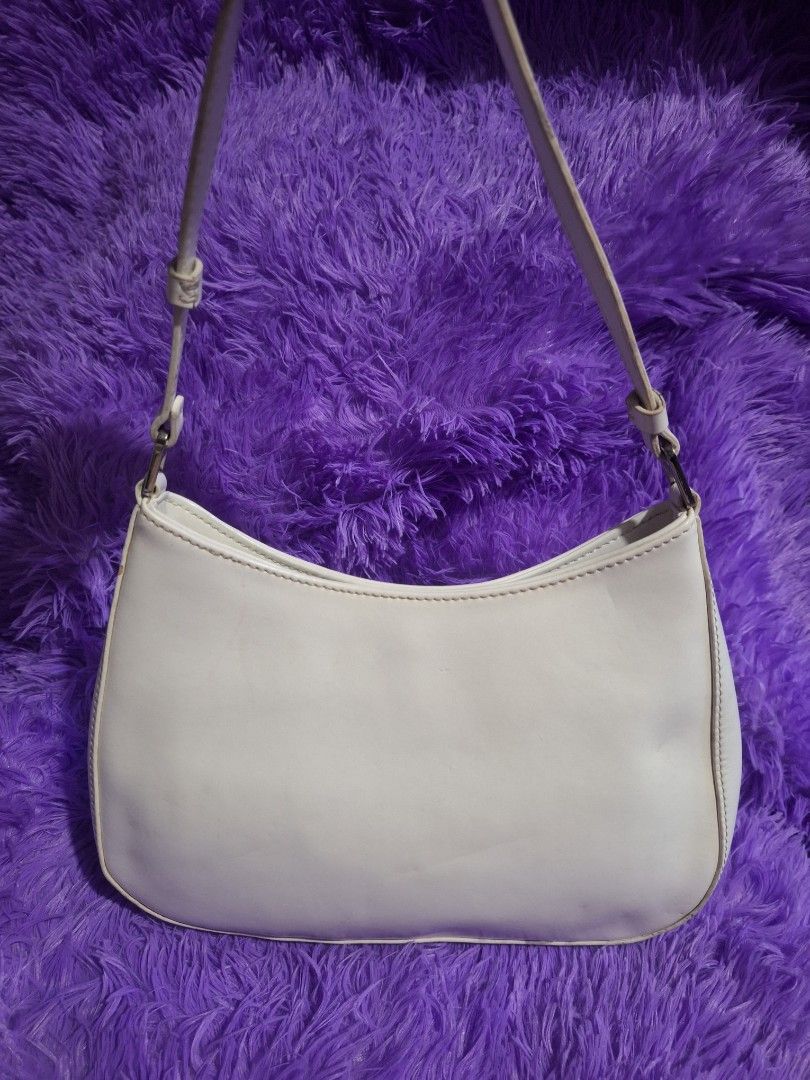 Prada CLEO White Leather Shoulder Bag (Category: Luxury Bags & Wallets) located in Quezon City. Submitted by cloudymay (Listing ID 1470202739, Image 2). Description: - Prada shoulder bag in classic white leather - Features the iconic enamel triangular logo plaque on the front - Sleek, slim profile with a structured silhouette - Silver-tone hardware accents at the strap connectors - Secure zip closure to keep daily essentials safe - Adjustable str