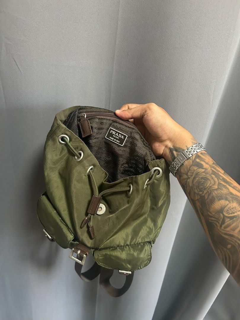 Prada nylon backpack in army green (Category: Backpacks) located in Bauang. Submitted by Fuzakenn (Listing ID 1470345350, Image 3). Description: - Authentic Prada backpack in army green nylon - Durable brown leather straps and silver-tone hardware - Secure drawstring and top flap closure with front pockets - Signature Prada jacquard fabric interior lining - Includes internal zip pocket and serial tag - Classic design, ideal for daily wear or trav