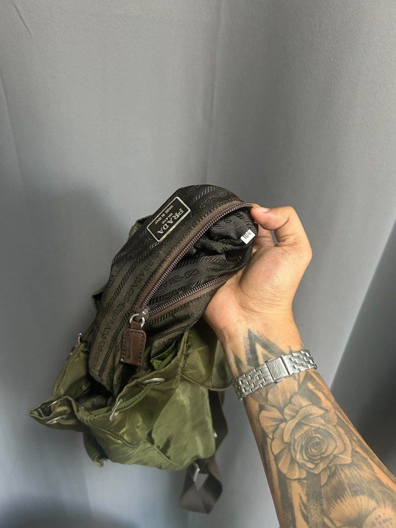 Prada nylon backpack in army green (Category: Backpacks) located in Bauang. Submitted by Fuzakenn (Listing ID 1470345350, Image 2). Description: - Authentic Prada backpack in army green nylon - Durable brown leather straps and silver-tone hardware - Secure drawstring and top flap closure with front pockets - Signature Prada jacquard fabric interior lining - Includes internal zip pocket and serial tag - Classic design, ideal for daily wear or trav