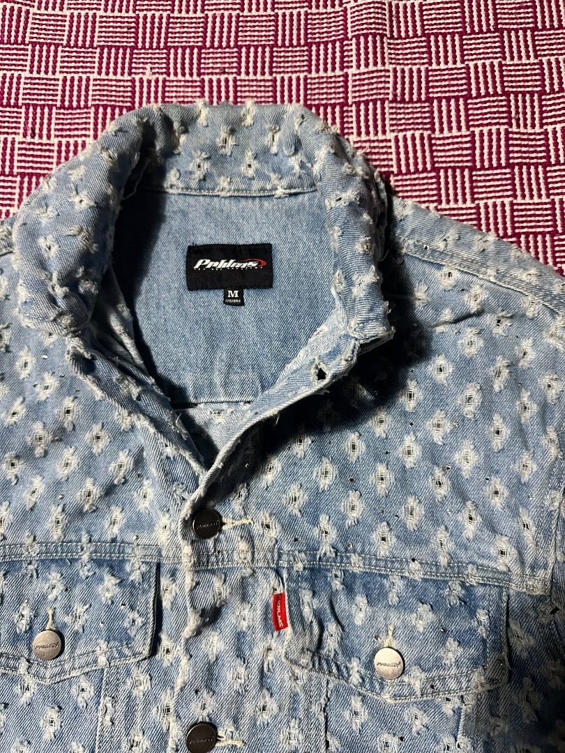 PRBLMS Distressed Light Wash Denim Jacket Size M (Category: Coats, Jackets and Outerwear) located in Manila. Submitted by wardrobeph.com (Listing ID 1470318670, Image 3). Description: - Brand: PRBLMS - Size: M - Wash: Light wash denim - Details: Heavy distressing with a raw hem finish - Back Design: Bold white chenille patch lettering spelling PRBLMS across the shoulders - Hardware: Metal button closures on front and chest pockets - Branding: Red