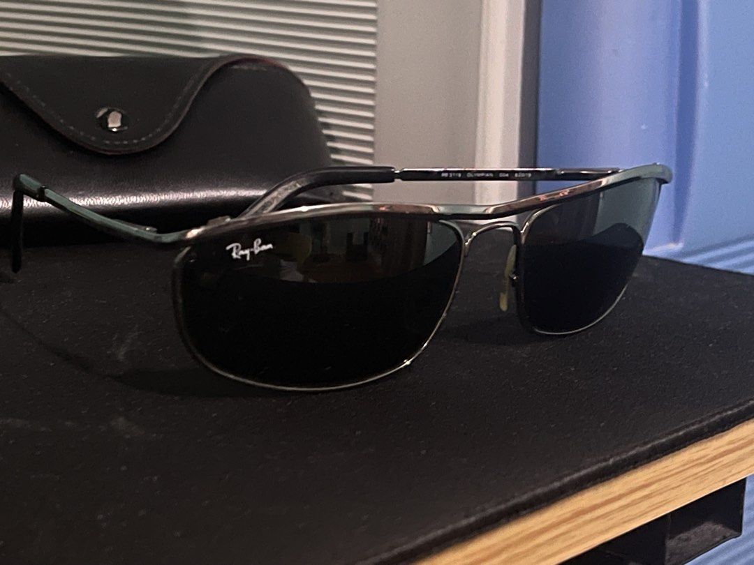 Ray-Ban Metal Frame Sunglasses with Case (Category: Sunglasses & Eyewear) located in Las Pinas. Submitted by marqusasasas (Listing ID 1470209487, Image 2). Description: - Brand: Ray-Ban - Frame: Dark metal, classic rectangular shape with minimal wear - Lenses: Black, clean condition with signature Ray-Ban logo on the left lens - Fit: Nose pads are completely intact - Inclusion: Original black leather hard case with snap button closure and gold em