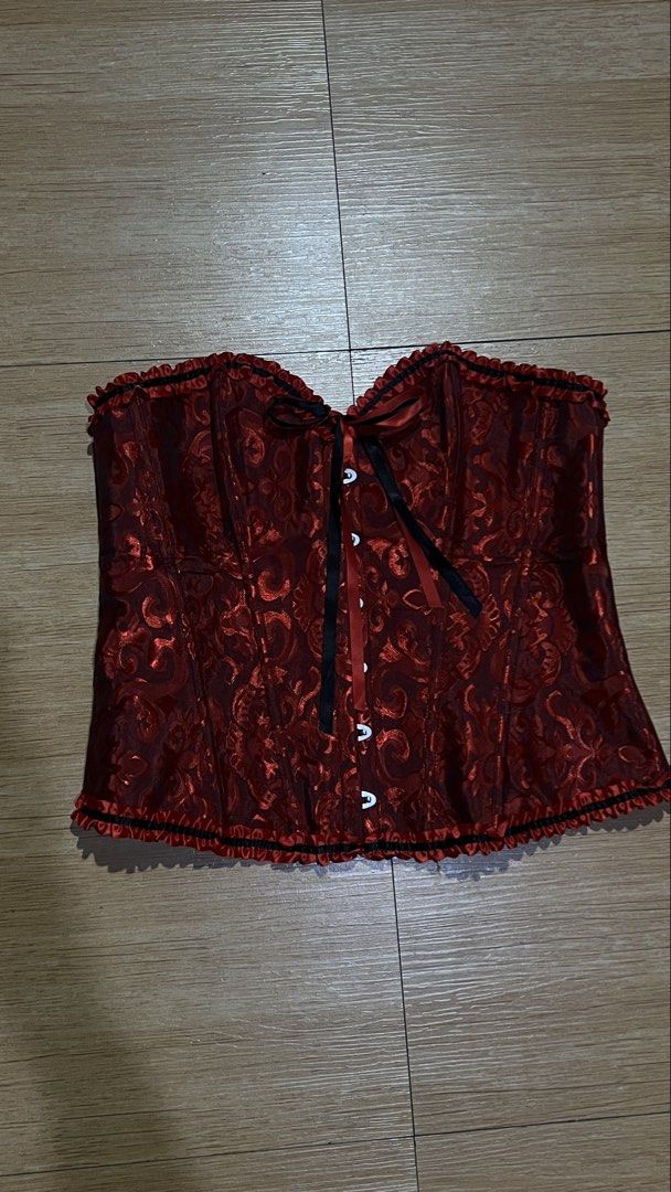 Red Brocade Corset Top with Ruffle Trim (Category: Sleeveless) located in Manila. Submitted by ekss11 (Listing ID 1470322186, Image 3). Description: - Design: red and black damask pattern - Neckline: Sweetheart style with ruffled trim - Closure: Front metal busk with loops, hooks, and ribbon ties - Fit & Structure: Vertical boning for body shaping - Details: Matching ruffles along the bottom hem.