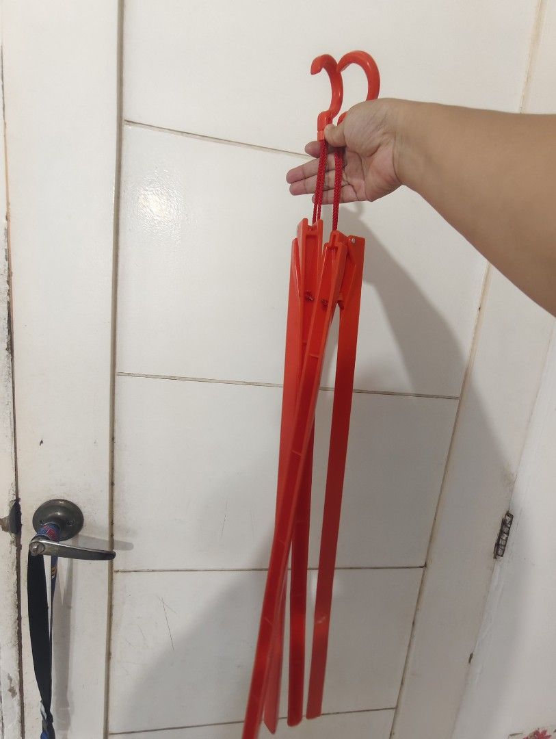 Red Foldable Multiple Clothes Hanger (Category: Hooks & Hangers) located in Bulacan. Submitted by babz30261 (Listing ID 1470262214, Image 1). Description: - Bright red collapsible clothes hanger for space-saving vertical storage - Folds up compactly, perfect for travel and easy storage twooo - Features sturdy hooks and red string cords - Made from durable, vibrant red plastic.