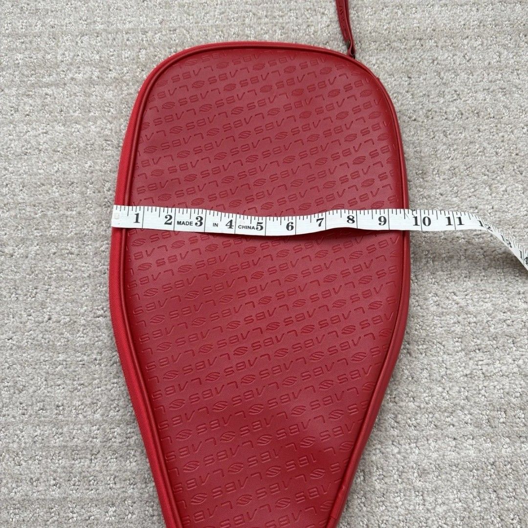 Red selkirk SLABS paddle Cover Bag (Category: Racket and Ball Sports) located in Batangas. Submitted by curatedluxxe88 (Listing ID 1470153569, Image 3). Description: - Brand: Selkirk - Color: Red with all-over debossed logo pattern - Closure: Smooth side zipper - Dimensions: Approx. 18 inches long x 11 inches wide - Condition: Clean shape, fully functional zipper - Ideal for storing and protecting your pickleball gear.