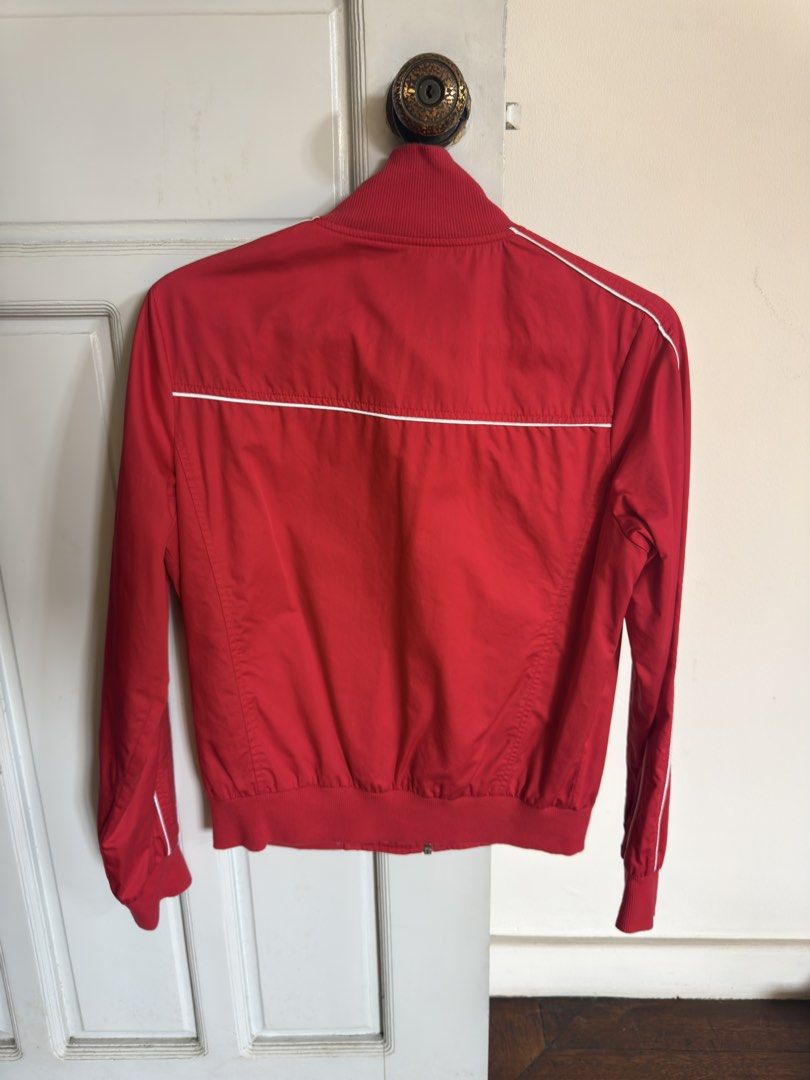 Red Track Jacket (Category: Coats, Jackets and Outerwear) located in Quezon City. Submitted by socutexx (Listing ID 1470220860, Image 2). Description: - Color: Bright red with white piping - Design: Silver glittery BSU OJO lettering with a crown graphic - Closure: Full zip with a unique star zipper pull - Pockets: Two side zippered pockets with star pulls - Details: Ribbed collar, cuffs, and hem for a snug fit - Condition: Excellent ready-to-wear